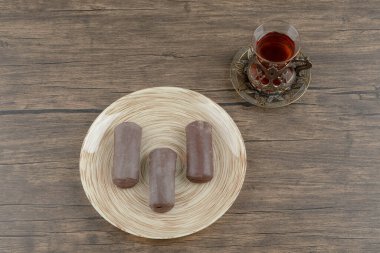 Tahta yüzeyinde bir bardak çay olan bir tabak çikolatalı kek. Yüksek kalite fotoğraf