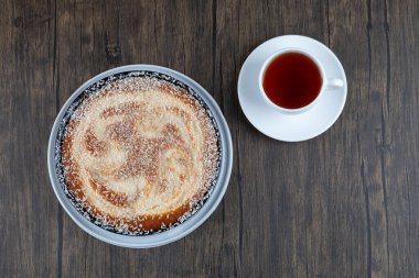 Tahta masaya bir fincan siyah çay ile bir tabak lezzetli turta. Yüksek kalite fotoğraf