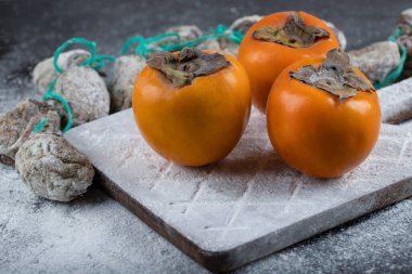 Siyah yüzeyde taze hurma ağaçları etrafında şeker tozu ile kurutulmuş hurma. Yüksek kalite fotoğraf