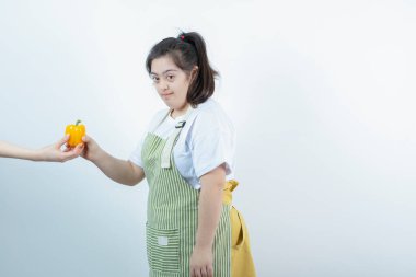 Kareli önlüklü genç kız sarı dolmalık biber veriyor. Yüksek kalite fotoğraf