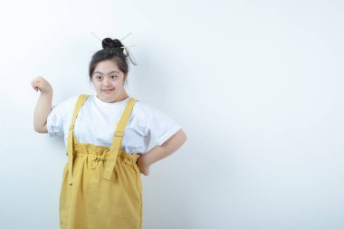 Beyaz duvara karşı duran ve poz veren genç, güzel bir kız. Yüksek kalite fotoğraf