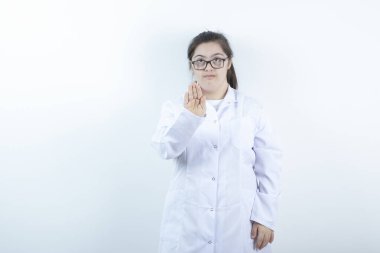 Doktor üniformalı genç bir bayan dur işareti yapıyor. Yüksek kalite fotoğraf
