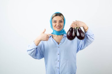 Mendilli, patlıcan tutan sarışın güzel bir kadın resmi. Yüksek kalite fotoğraf