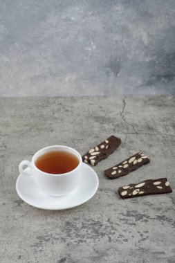 Cup of black tea with cocoa crackers on stone table. High quality photo