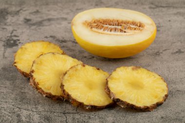Taş zeminde sulu olgun ananas dilimleri ve sarı kavun. Yüksek kalite fotoğraf