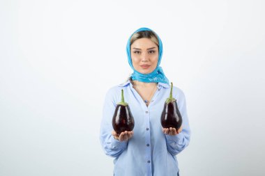 Mendilli, patlıcan tutan sarışın güzel bir kadın resmi. Yüksek kalite fotoğraf