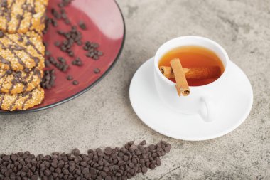 Kırmızı tabak tatlı bisküvi ve bir fincan siyah çay. Yüksek kalite fotoğraf