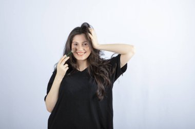 Beyaz arka planda fırçayla allık süren genç ve güzel bir model resmi. Yüksek kalite fotoğraf