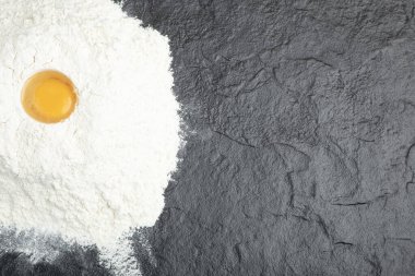 Siyah yüzeyde çiğ yumurta sarısı ve un ile ekmek hazırlığı. Yüksek kalite fotoğraf