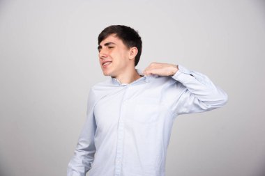 Gri arka planda sıcak hisseden genç erkek çalışanın portresi. Yüksek kalite fotoğraf