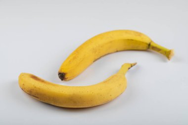 Beyaz arka plana yerleştirilmiş iki olgun sarı muz. Yüksek kalite fotoğraf