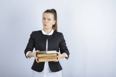 Genç bir öğrencinin beyaz arka plandaki birine kitap vermesi. Yüksek kalite fotoğraf