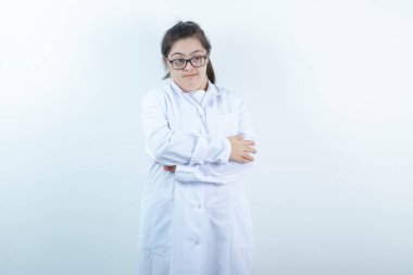 Doktor üniformalı genç bir kız kollarını kavuşturmuş duruyor. Yüksek kalite fotoğraf