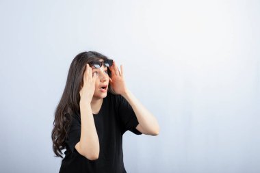 Beyaz arka planda güneş gözlüğüyle poz veren şık bir genç kadın. - Evet. Yüksek kalite fotoğraf