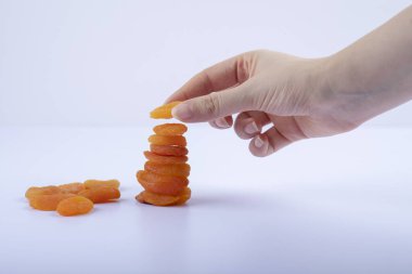 Beyaz arka planda kurumuş kayısı yiyen bir kadın. Yüksek kalite fotoğraf