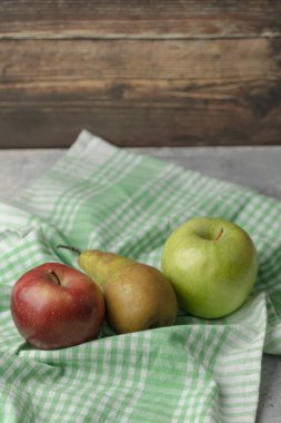 Yeşil masa örtüsü üzerinde taze armut olan kırmızı ve yeşil elmalar. Yüksek kalite fotoğraf