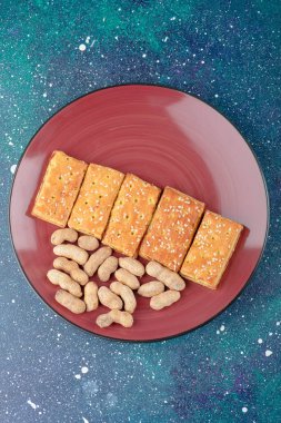 Sağlıklı fındıklı kırmızı bir tabak ve galaksi arka planında lezzetli krakerler. Yüksek kalite fotoğraf