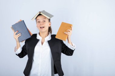 Kafasında bir sürü kitap olan güzel bir öğretmenin resmi. Yüksek kalite fotoğraf