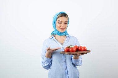 Elinde ahşap domates tahtası olan mendilli güzel bir kadın resmi. Yüksek kalite fotoğraf