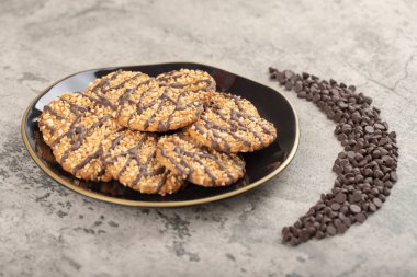 Siyah yulaflı bisküvi tabağı ve çikolatayı taş masaya bırak. Yüksek kalite fotoğraf