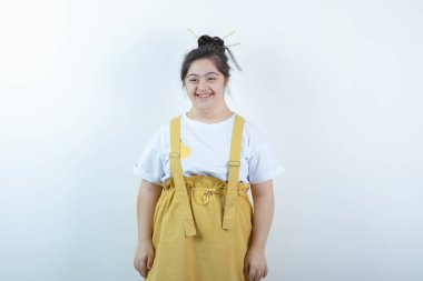 Beyaz duvara karşı duran ve poz veren genç, güzel bir kız. Yüksek kalite fotoğraf