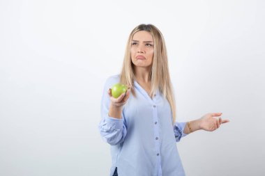 Çekici bir kadın modelin yeşil bir elma tutarken çekilmiş portresi. Yüksek kalite fotoğraf