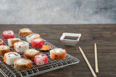 Çeşitli suşi çeşitleri, yemek çubukları ve soya sosuyla ahşap arka planda. Yüksek kalite fotoğraf