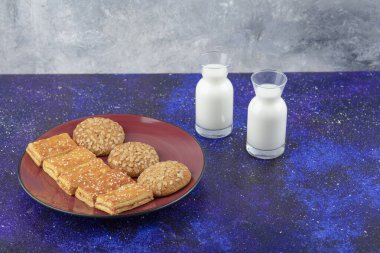 Lezzetli krakerler ve cam sürahilerle dolu kırmızı bir tabak sağlıklı kurabiye. Yüksek kalite fotoğraf