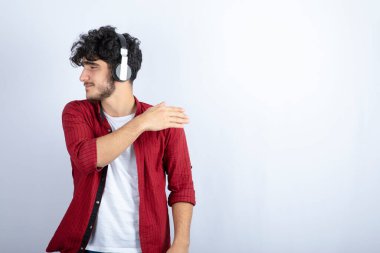 Kulaklıklı bir gencin beyaz arka planda bir yerlere baktığı bir görüntü. Yüksek kalite fotoğraf