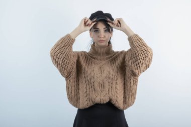 Beyaz duvarda örgü giysili güzel bir kadın resmi. Yüksek kalite fotoğraf