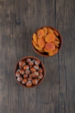 Sağlıklı fındıklı kurutulmuş kayısı meyveleriyle dolu ahşap bir kase. Yüksek kalite fotoğraf