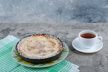 Taş bir masanın üzerine bir fincan siyah çay ile bir tabak lezzetli turta. Yüksek kalite fotoğraf
