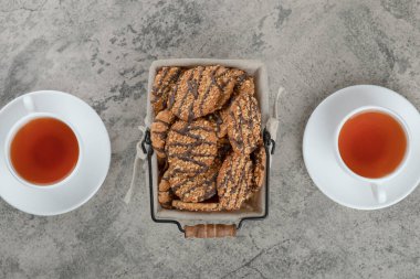 İki fincan siyah çay, içinde bir sepet lezzetli kurabiye ve tohumlar olsun. Yüksek kalite fotoğraf