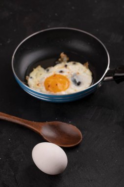 Kızartma tavasında nefis kızarmış yumurta ve siyah yüzeyde çiğ beyaz yumurta. Yüksek kalite fotoğraf