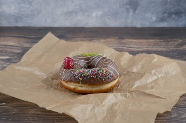 Çikolata kaplamalı, yağsız kağıda yapıştırılmış bir parça çikolatalı çörek. Yüksek kalite fotoğraf