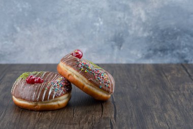 Ahşap masada çikolata kaplı iki lezzetli çörek. Yüksek kalite fotoğraf