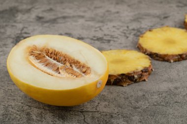 Yarım dilimlenmiş kavun dilimlenmiş, arka planda doğranmış ananas. Yüksek kalite fotoğraf