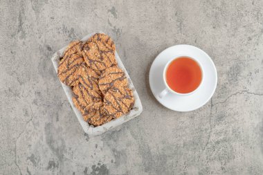 Sepette çikolata jöleli leziz çoklu tahıllı kurabiyeler ve bir fincan çay. Yüksek kalite fotoğraf