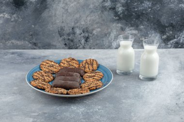 Mavi tabak dolusu çikolatalı kek ve taze sütlü kepekli kurabiye. Yüksek kalite fotoğraf