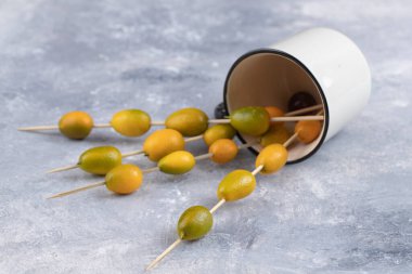 Mermer zemin üzerinde olgun kumkatlarla dolu yemek çubuklarıyla dolu bir fincan. Yüksek kalite fotoğraf