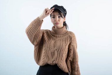 Beyaz duvarda örgü giysili güzel bir kadın resmi. Yüksek kalite fotoğraf