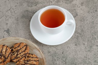 Susamlı kurabiyeler ve mermer yüzeyde bir fincan çay. Yüksek kalite fotoğraf