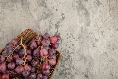 Mermer masanın üzerinde kırmızı üzüm sepeti var. Yüksek kalite fotoğraf