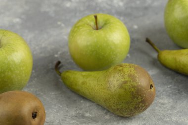 Taze yeşil armutlar ve mermer zemin üzerinde organik elmalar. Yüksek kalite fotoğraf