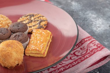 Kırmızı tabakta tatlı atıştırmalıklar taştan bir arka planda. Yüksek kalite fotoğraf