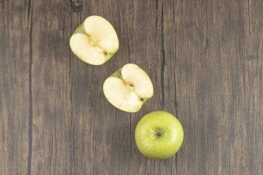 Yeşil organik elmalar. Yarısı kesilmiş ya da ahşap arka planda koca bir elma. Yüksek kalite fotoğraf