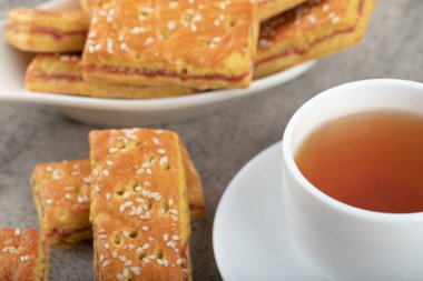 Taş bir masanın üzerine kraker konmuş beyaz fincan sıcak çay. Yüksek kalite fotoğraf