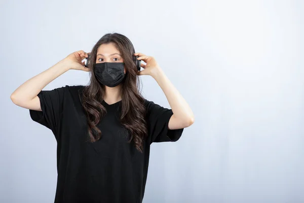 Brunette Woman Medical Mask Listening Music Headphones High Quality Photo — Stock Photo, Image