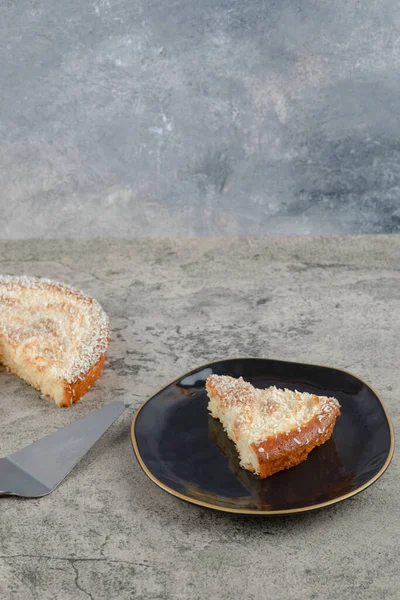 Taş zeminde siyah bir tabak lezzetli vanilyalı kek. Yüksek kalite fotoğraf