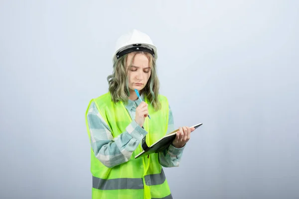 Фото Молодой Женщины Инженера Пишущей Свои Идеи Блокноте Над Белой — стоковое фото